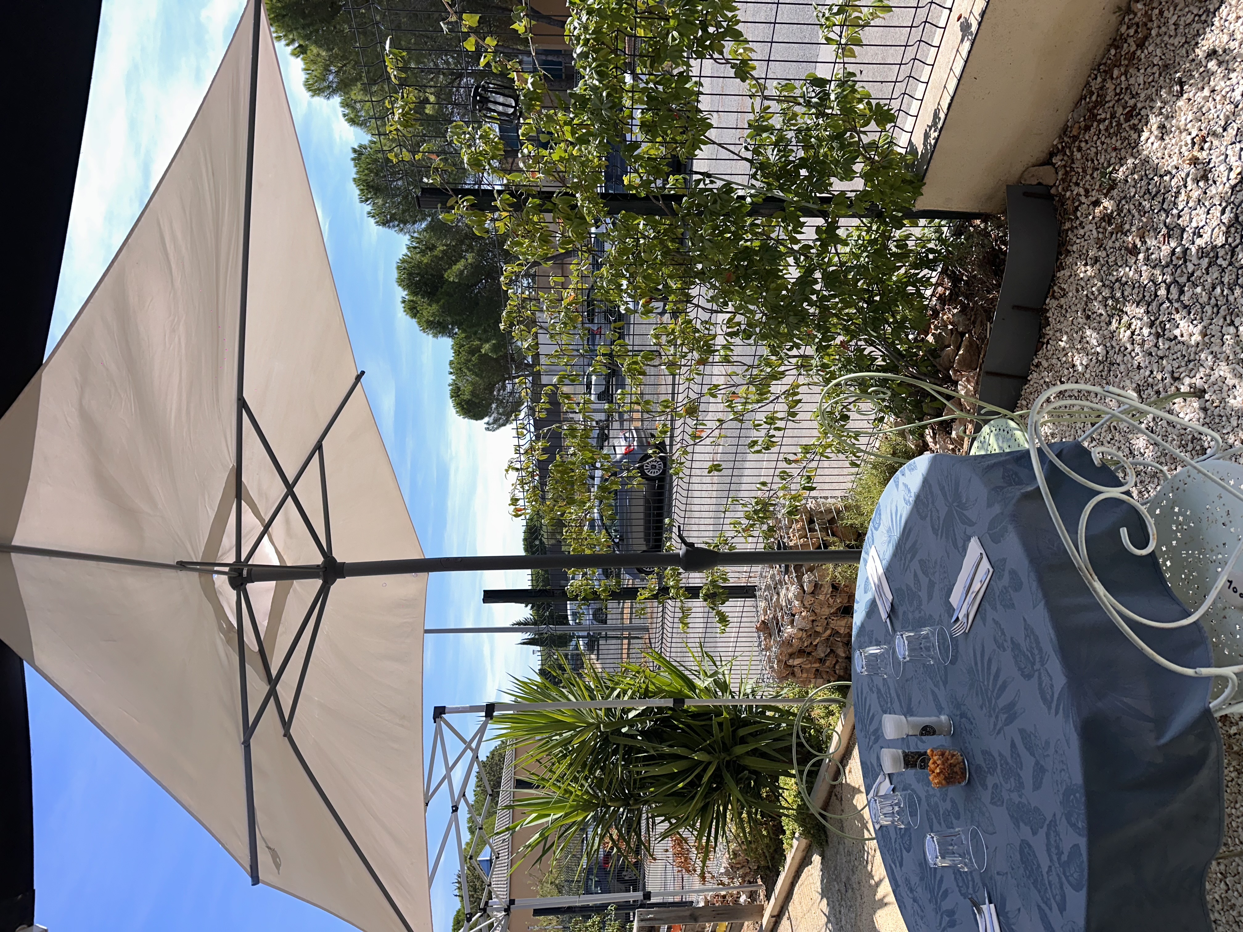 Table en terrasse sous parasol — La Famille